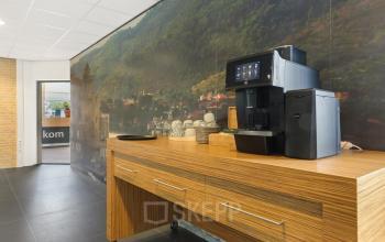 Kantoorruimte huren met muurdecoratie en koffiezetapparaat op houten kast in Emmen, Hoenderkamp 20.