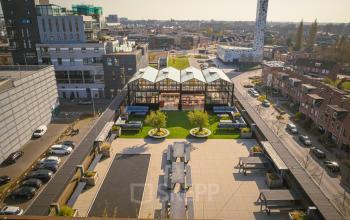Kantoorpand aan de Brouwerijstraat 1 in Enschede, met modern exterieur en dakterras. Gebouwen omliggend met stadszicht.