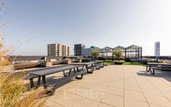 Modern kantoorpand op Brouwerijstraat 1 in Enschede met ruime daktuin en zitgelegenheden, ideaal voor een ontspannen werkpauze.