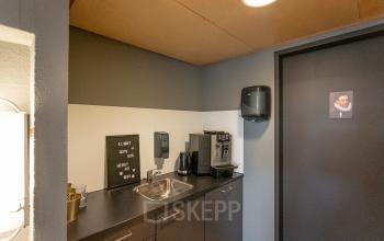 Kantoorpand op Wethouder Beversstraat 185 in Enschede met een pantry voorzien van een gootsteen, koffiezetapparaat en opbergruimte.