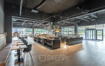 Ruime entreehal van het kantoorpand op Wethouder Beversstraat 185, Enschede, met moderne inrichting en veel natuurlijk licht. Perfect voor wie kantoorruimte wil huren in een inspirerende omgeving.