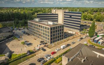 Buitenzicht van een modern kantoorpand op Moutlaan 1-23 in Enschede, ideaal voor bedrijven die kantoorruimte willen huren. Het gebouw is omgeven door voldoende parkeergelegenheid.