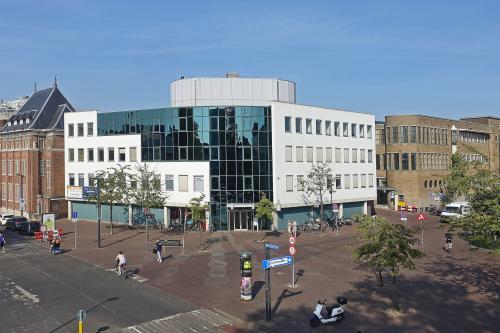 Kantoorpand aan Hoedemakerplein 2, Enschede met moderne glazen gevels en stedelijke omgeving, ideaal voor kantoorruimte huren.