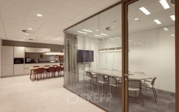 Moderne kantoorruimte met glazen vergaderruimte en kitchenette, geschikt voor vergaderingen in Enschede. Ideaal voor bedrijven die een kantoorpand willen huren op Kuipersdijk 2-4.