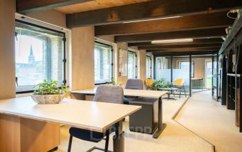 Kantoorruimte huren op Prins Hendrikkade 3 in Franeker met houten details, moderne bureaus en grote ramen met uitzicht over de stad.