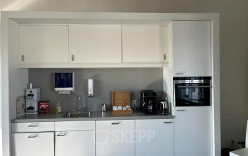 Moderne pantry in kantoorpand aan Techniekweg 15, Gorinchem met kasten, koffiezetapparaat en spoelbak, ideaal voor kantoorruimte huren.