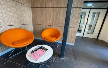 Kantoorruimte huren op Techniekweg 15 in Gorinchem, met moderne voorzieningen en een wachtruimte met oranje stoelen en een tafel.