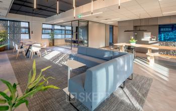 Interieur van een modern kantoorpand met blauw meubilair en veel daglicht, perfect voor wie kantoorruimte wil huren op Tielweg 30 in Gouda.
