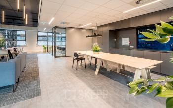 Moderne kantoorruimte op Tielweg 30 in Gouda met strakke, functionele inrichting, grote vergadertafel en veel natuurlijk lichtinval, ideaal voor bedrijven die optimaal willen huren.
