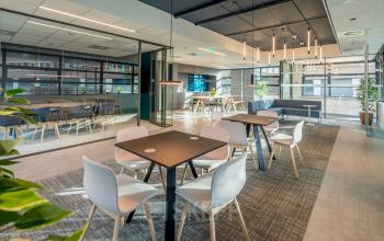 Moderne kantoorruimte te huur op Tielweg 30 in Gouda, met stijlvolle inrichting en veel natuurlijk licht. Deze ruimte is ingericht met tafels en stoelen, ideaal om te werken of voor zakelijke bijeenkomsten.