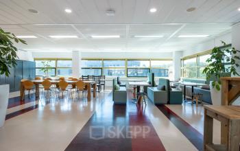 Ruime kantoorruimte te huur op Groningenweg 8 8 in Gouda met grote ramen, moderne meubels en veel natuurlijk licht, ideaal voor werk of vergaderingen.