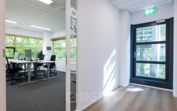 Kantoorruimte aan Groningenweg 8 8, Gouda met moderne bureaus, stoelen, en veel natuurlijk licht. Geschikt voor bedrijven die een kantoorpand willen huren.