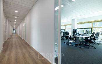 Gezellige kantoorruimte te huur op Groningenweg 8 8 in Gouda met meerdere werkplekken en bureaus in een lichte, moderne inrichting.