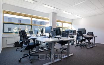 Lichte kantoorruimte in Gouda aan Groningenweg 8 8 met diverse bureaus en stoelen, ideaal voor kantoor huren. Grote ramen zorgen voor veel natuurlijk licht.