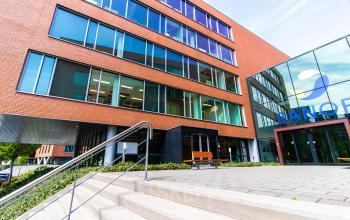 De buitenzijde van het kantoorpand aan Kampenringweg 45 in Gouda, met moderne architectuur en grote ramen. Ideaal voor wie kantoorruimte wil huren in een aantrekkelijke omgeving.