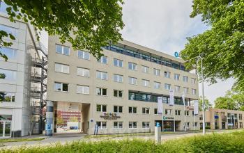 Exterieur van het kantoorpand aan de Leonard Springerlaan 7, Groningen, met opvallende gevel en groene omgeving. Perfecte locatie voor bedrijven die kantoorruimte willen huren in een levendige stedelijke omgeving.