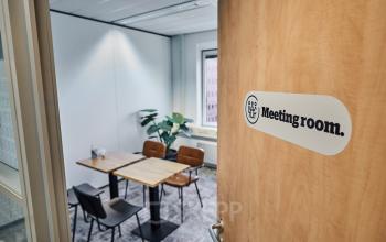 Vergaderruimte met houten tafel en vier stoelen in kantoorpand aan de Leonard Springerlaan 7, Groningen. Ideaal voor bedrijven die een flexibele kantoorruimte willen huren.