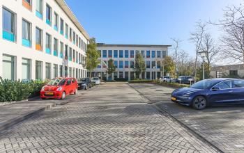 Buitenzicht op het kantoorpand op Zernikepark 12, Groningen met parkeerplaatsen en moderne architectuur.