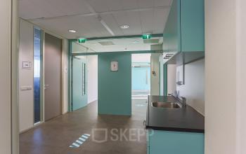 Modern kantoorpand op Zernikepark 12 in Groningen met turquoise muren en een kleine kitchenette. Uitgebreide mogelijkheden voor kantoorruimte huren, functionele werkplek en voorzieningen.