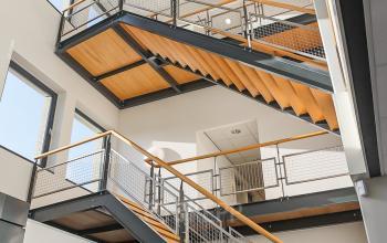 Binnenkant van een modern kantoorpand op Zernikepark 12, Groningen, met een architectonisch opvallende trappenhal. Het interieur straalt moderniteit uit, ideaal voor kantoorruimte huren.