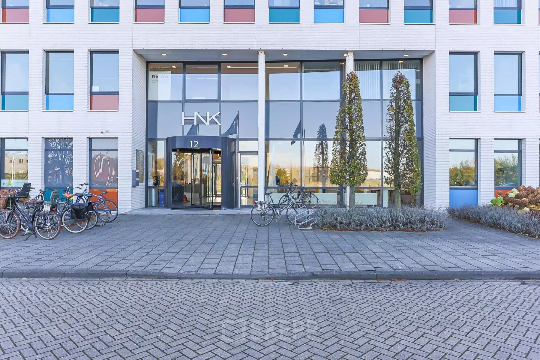 Zernikepark 12 in Groningen toont een modern kantoorpand met grote ramen en fietsen voor de entree. Ideale locatie voor kantoorruimte huren met een professionele uitstraling.