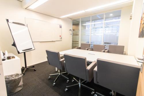 Vergaderruimte in een kantoorpand op Paterswoldseweg 806, Groningen met kantoormeubilair, een whiteboard en een flipover.