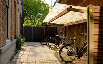 Buitenruimte bij kantoorpand op Kennemerplein 20, Haarlem Centraal Station, met fietsen onder een afdak.