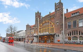 Voorgevel van het historische kantoorpand op Kennemerplein 20 bij Haarlem Centraal Station, met duidelijke architectonische details en de ingang zichtbaar.