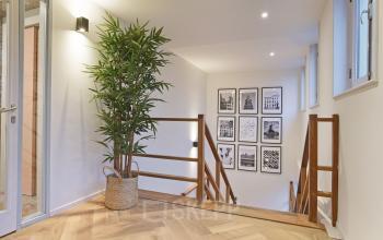 Moderne, lichte ontvangstruimte van kantoorpand op Kennemerplein 20 bij Haarlem Centraal Station, voorzien van kunst en planten.