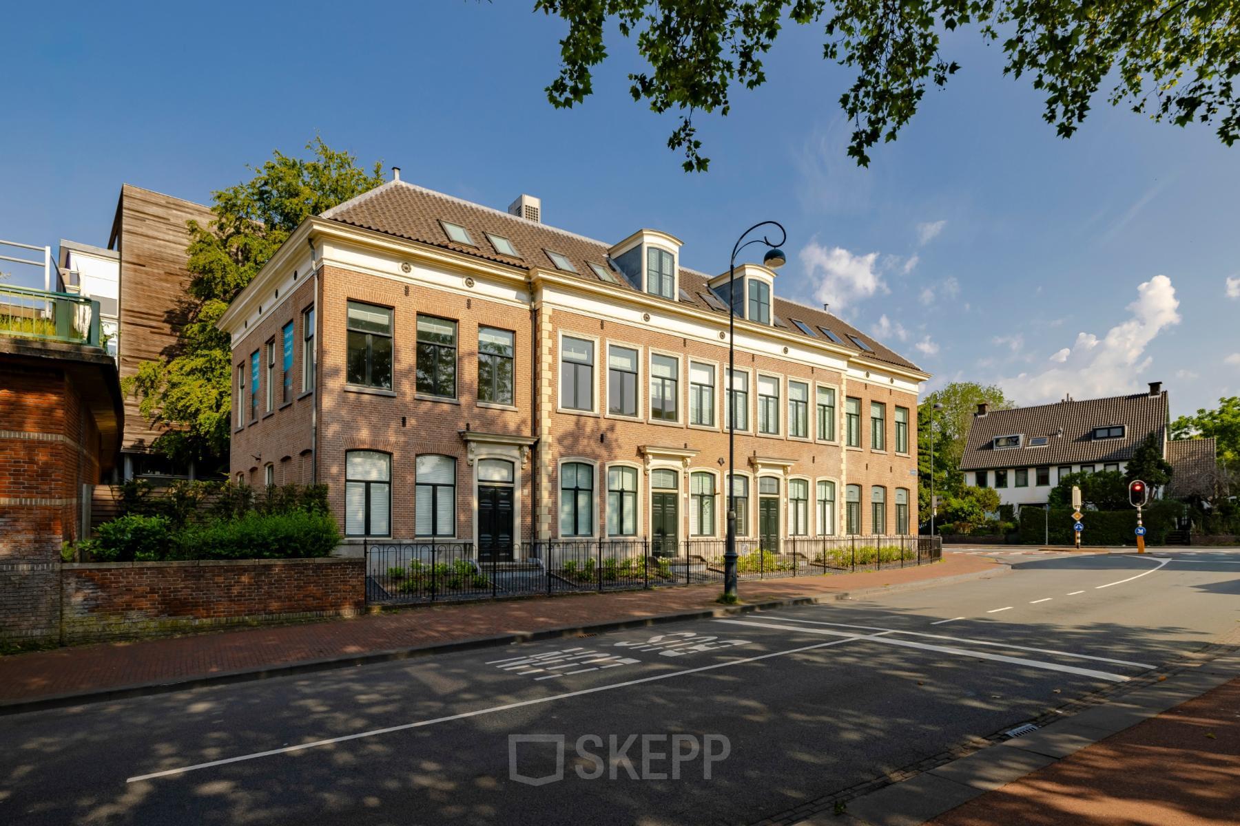Gevel van het kantoorpand aan Kennemerplein 20, Haarlem Centraal Station, met klassieke bakstenen architectuur en een rustige straatomgeving.