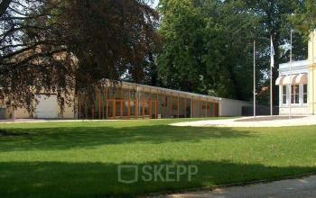 Exterieur van het kantoor aan Staten Bolwerk 1, Haarlem Centraal Station, omgeven door groene bomen en grasvelden.