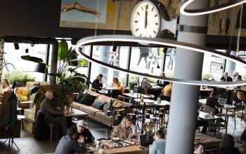 Huur kantoorruimte aan het Kennemerplein 6-14 in Haarlem Centraal Station. Werkplekken met tafels, comfortabele zitbanken en actieve professionals in een modern en inspirerend kantoorpand.