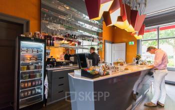 Modern ingerichte kantoorpand met een pantry waar een persoon aan het werk is bij Nieuwe Gracht 3 in Haarlem Centrum.