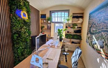 Kantoorruimte huren in Haarlem Centrum met een groen accentmuur, moderne bureaus en veel natuurlijk licht. Gelegen op Koepelplein 1E, biedt het een inspirerende werkomgeving.