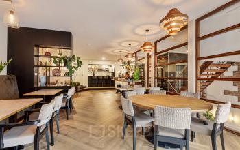 Foto van een gemeubileerde kantoorruimte op Grote Houtstraat 176-180, Haarlem Centrum, met ronde tafels en stoelen, ideaal voor vergaderingen of informeel werken.