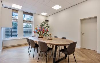 Kantoorruimte huren in Haarlem Centrum op Grote Houtstraat 176-180 met een vergadertafel en stoelen, lichte ruimte met groot raam.