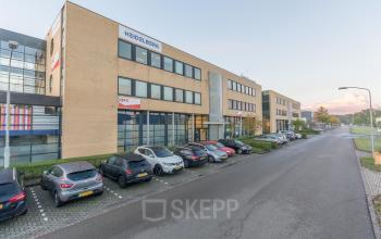 Exterieur van een zakelijk kantoorpand aan de Mollerusweg 84 in Haarlem Waarderpolder met ruime parkeergelegenheid voor het gebouw.