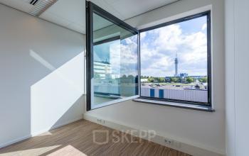 Modern kantoorpand aan de Mollerusweg 84 in Haarlem Waarderpolder met een open raam dat een uitzicht biedt over de omgeving.