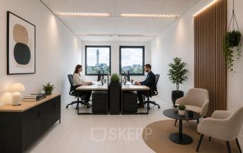 Moderne kantoorruimte huren in Haarlem Waarderpolder, met strakke inrichting, planten en bureauopstellingen. Twee mensen zijn bezig met zakelijke werkzaamheden.