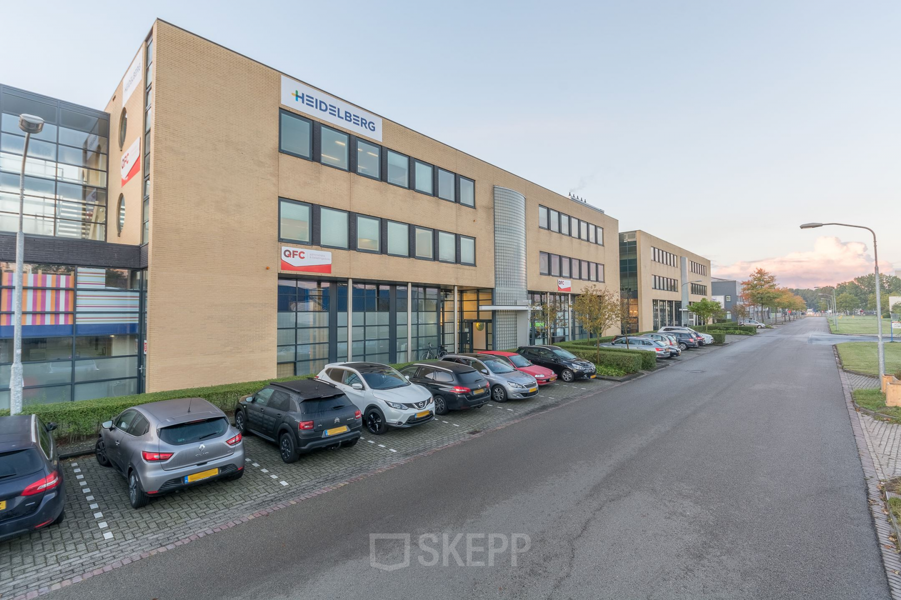 Modern ogend kantoorpand aan Mollerusweg 84 in Haarlem Waarderpolder, met een gevulde parkeerplaats voor het gebouw.