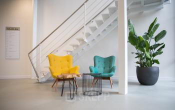 Moderne ontvangstruimte in kantoorpand op Bingerweg 18A-18R, Haarlem Waarderpolder, met stijlvolle zitstoelen en planten. Ideaal voor bedrijven die kantoorruimte willen huren in een eigentijdse omgeving.