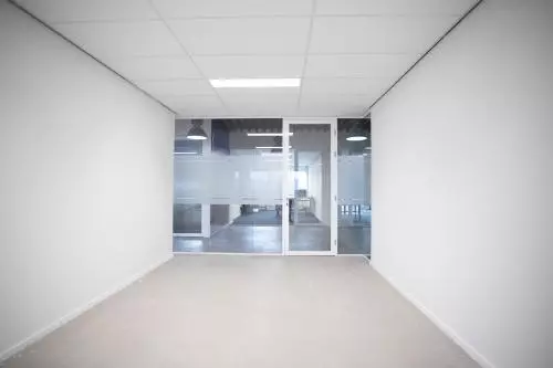 Leeg kantoorpand op Bingerweg 18A - 18R in Haarlem Waarderpolder met glazen scheidingswanden en neutrale vloer. Ruimte geschikt voor kantoorruimte huren.