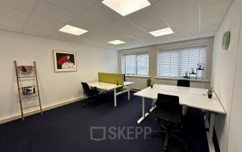 Kantoorruimte huren aan de Waarderweg 33 in Haarlem Waarderpolder, met drie bureaus, zwarte stoelen en modern interieur. Grote ramen zorgen voor natuurlijk licht in het kantoorpand.