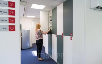 Kantoorruimte huren aan Waarderweg 33 in Haarlem Waarderpolder. Een medewerker plaatst een tas in een kast in een nette werkruimte met stijlvolle kasten en bewegwijzering. Modern en functioneel ingericht.