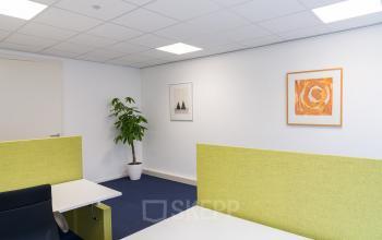Kantoorruimte huren op Waarderweg 33 in Haarlem Waarderpolder, modern ingericht met frisse groene scheidingswanden en kunst aan de muur, ideaal voor een inspirerende werkomgeving.