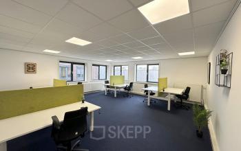 Licht en ruim kantoor in Waarderpolder, Haarlem met meerdere werkstations en bureaustoelen. Grote ramen zorgen voor veel daglicht, ideaal voor huren als kantoorruimte.