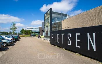 Exterieur van kantoorpand aan Waarderweg 52 in Haarlem Waarderpolder. Voorzijde met parkeerplaats, groenvoorziening en grote gevelreclame. Mogelijkheid tot kantoorruimte huren in deze bedrijfsomgeving.