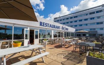 Terras van een restaurant met diverse zitplaatsen bij het kantoorpand gelegen aan A. Hofmanweg 5A, Haarlem Waarderpolder.