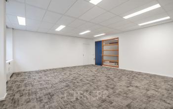 Lege kantoorruimte met tapijtvloer en witte muren op A. Hofmanweg 5A, Haarlem Waarderpolder. Ideaal voor kantoren die flexibiliteit in inrichting zoeken bij het huren van kantoorpanden.