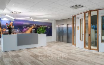 Moderne kantoorruimte huren in het kantoorpand aan A. Hofmanweg 5A, Haarlem Waarderpolder met een receptiebalie, kunst aan de muur en lifttoegang. De ruimte is ingericht en klaar voor gebruik.